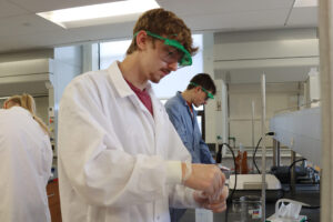 Male student conducting a chemistry experiement in a lab
